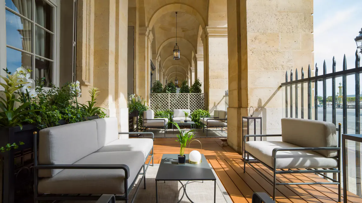 Classical courtyard with arched stone ceiling, ornate railings, and sculptural details
