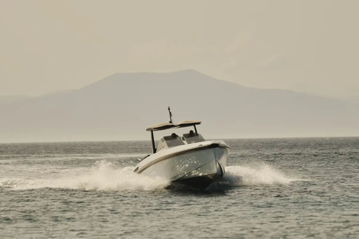 Speedboat on the water with mountain coastline backdrop