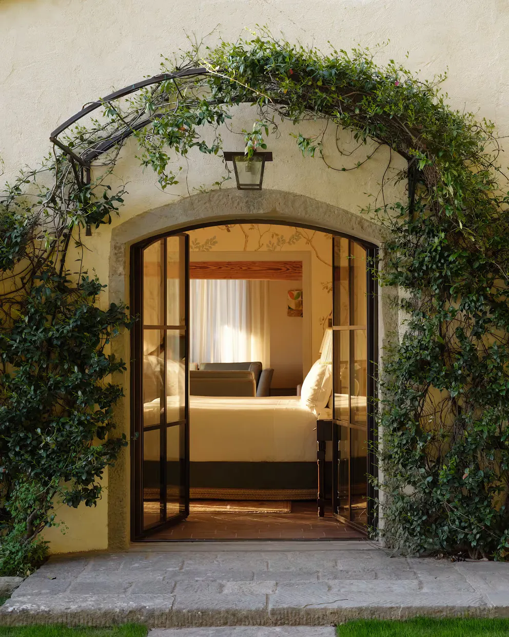 The ivy-framed garden doorway of the Limonaia suite opening onto its bedroom