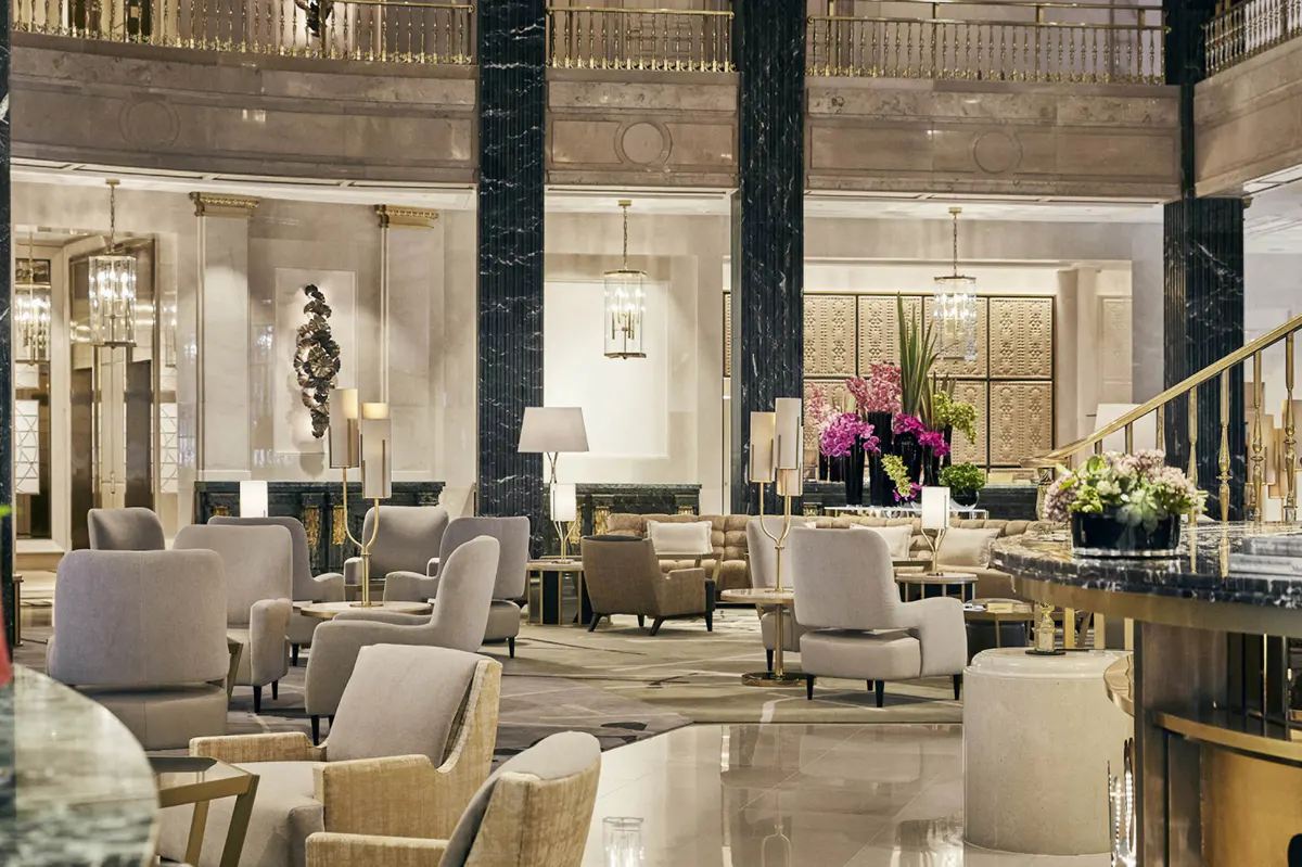 Restaurant with tall ceilings, black columns, neutral furnishings, and ornamental wall decor