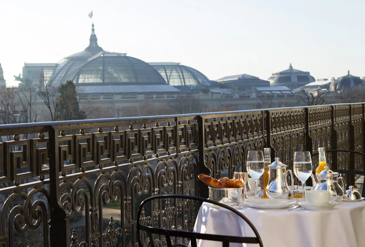 A rooftop dining table overlooking Paris with domes and architecture visible