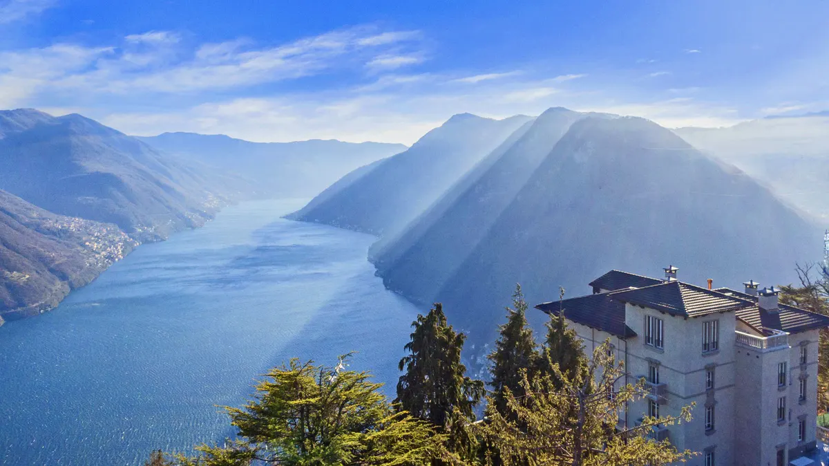 The villa positioned on a hillside with panoramic views of Lake Como and mountains