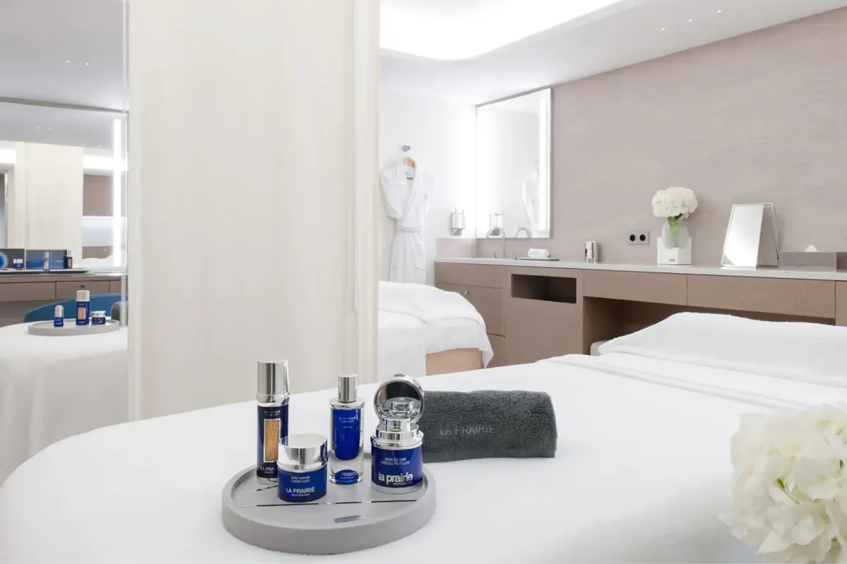 Spa vanity counter with blue-toned skincare bottles and towels