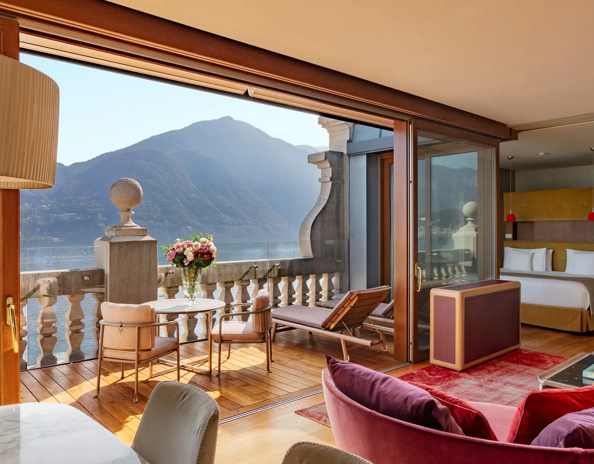 Suite sitting area with mountain-lake terrace and burgundy lounge seating