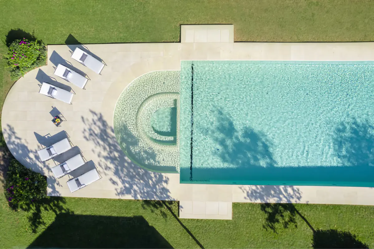 Aerial view of pool and grounds with lush landscaping and Mediterranean coastline