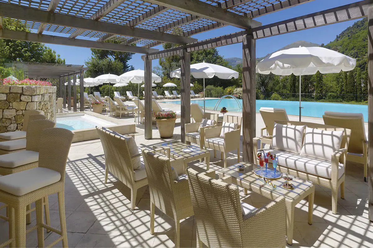 Pergola dining area with tables and chairs on terracotta stone paving