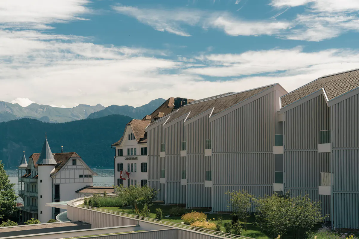 Building exterior in corrugated metal with lake and mountain backdrop against blue sky