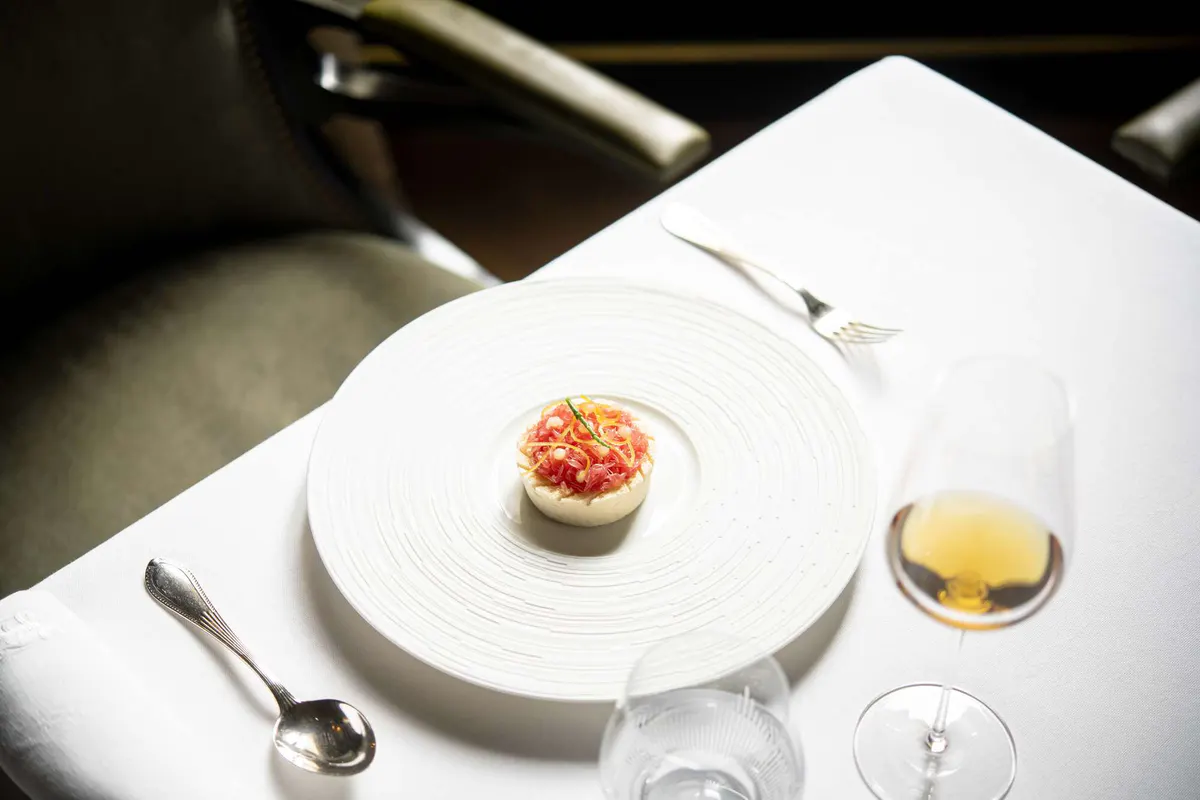 A delicate course with white wine and table settings in soft light