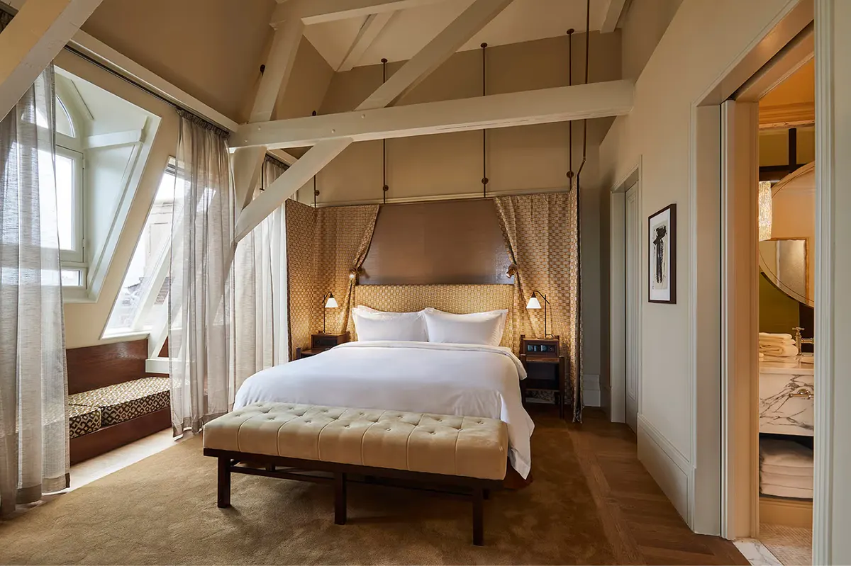 Bedroom with four-poster canopy bed, white linens, and sheer drapes with river views