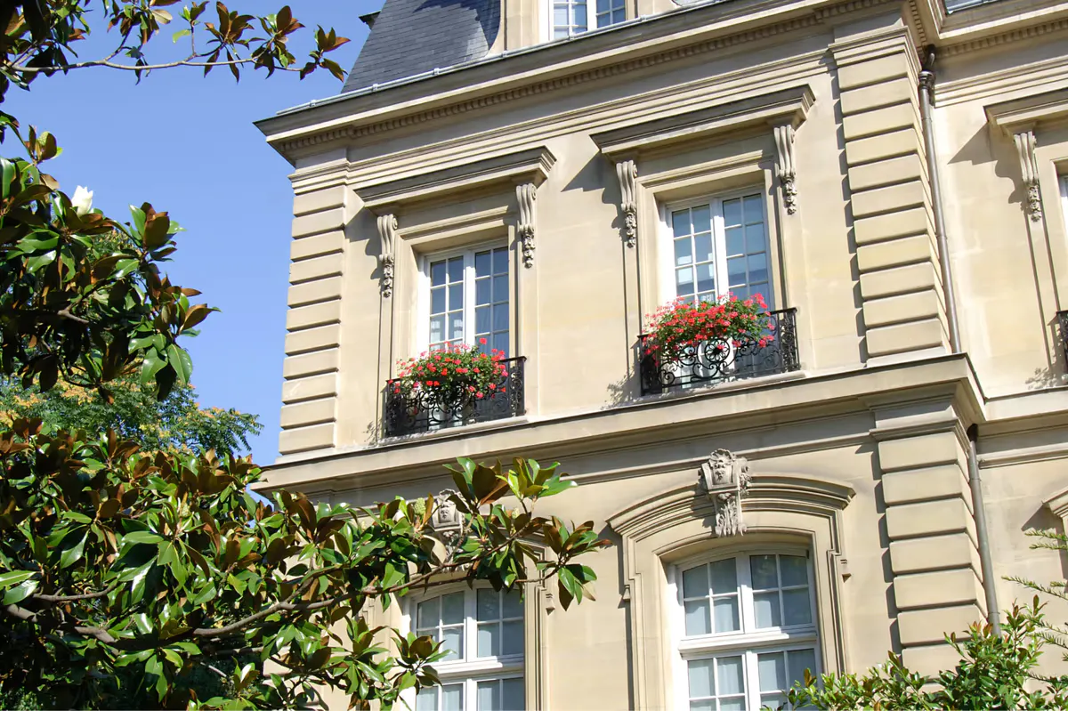 Gardener tending flowerbeds in lush landscaped grounds