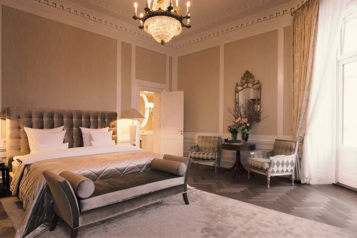 Bedroom in dusty rose tones with upholstered headboard and pendant lights