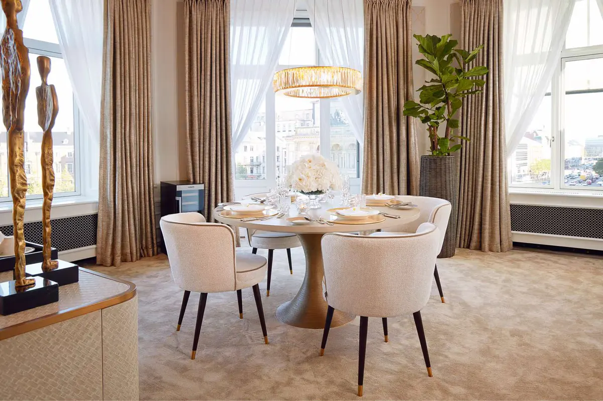 Parlor room with round dining table, natural light, and curtained windows