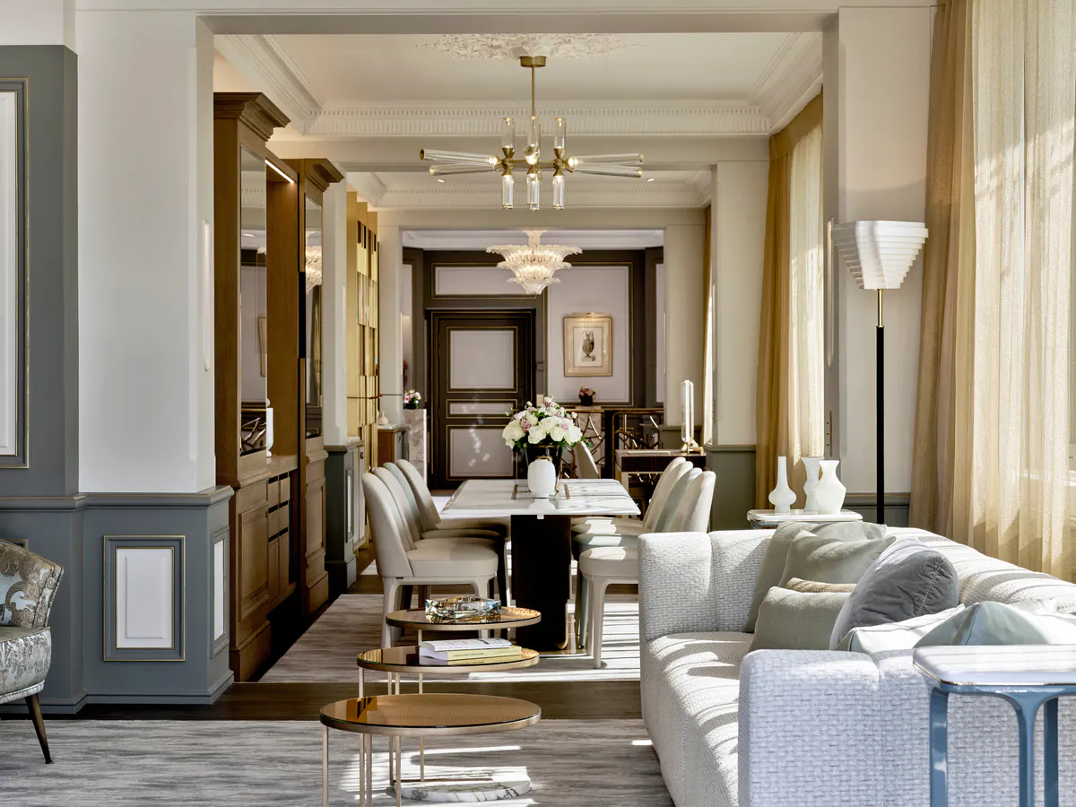 A hallway in the hotel with elegant dark wood doors, pale green-gray walls, and classical details