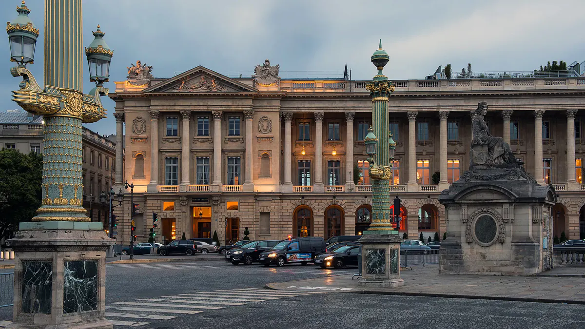 Building facade illuminated at dusk on Paris street corner with classical proportions