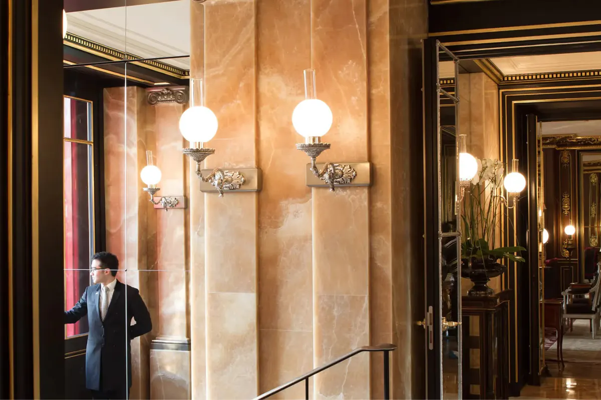 An interior corridor with stone walls and globe pendant lights