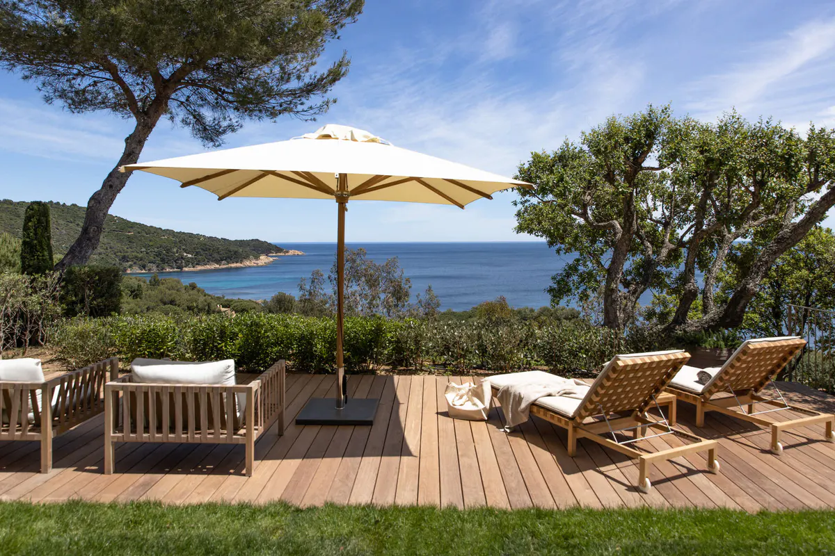 Shaded deck with wooden lounges overlooking the Mediterranean Sea