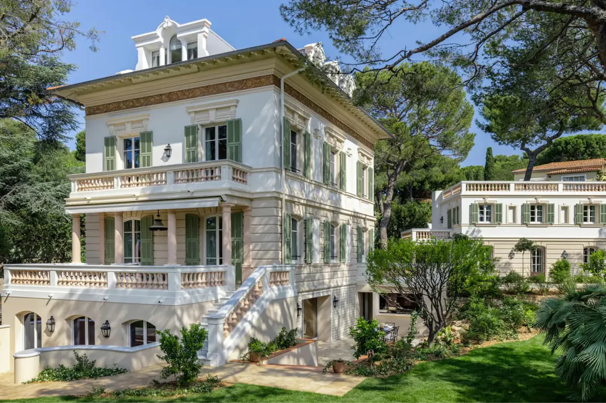 Pale cream villa with mansard roof and manicured gardens
