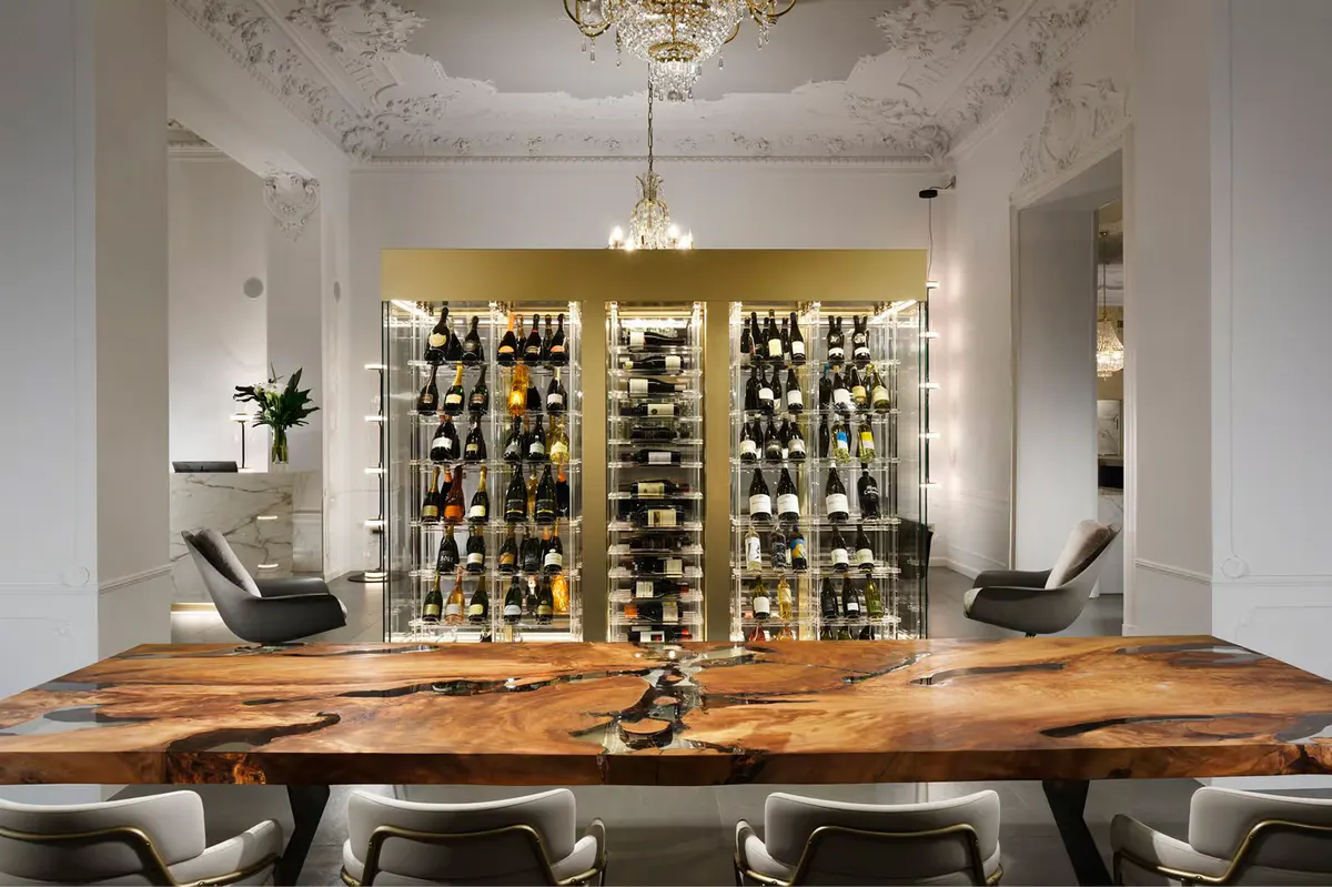 A wine bar interior with a raw wood counter and shelving holding bottles