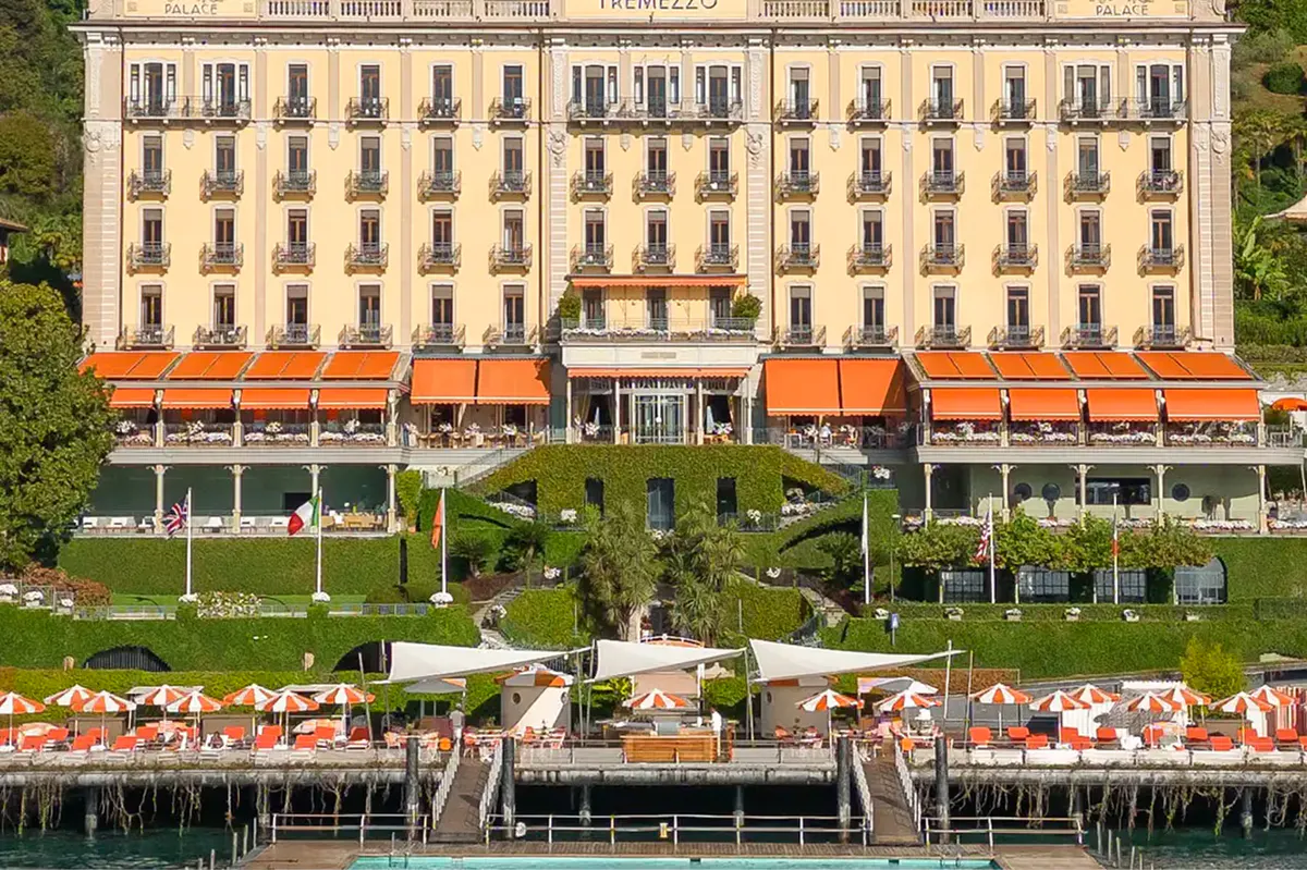 The palatial facade of the Art Nouveau hotel with orange awnings facing Lake Como