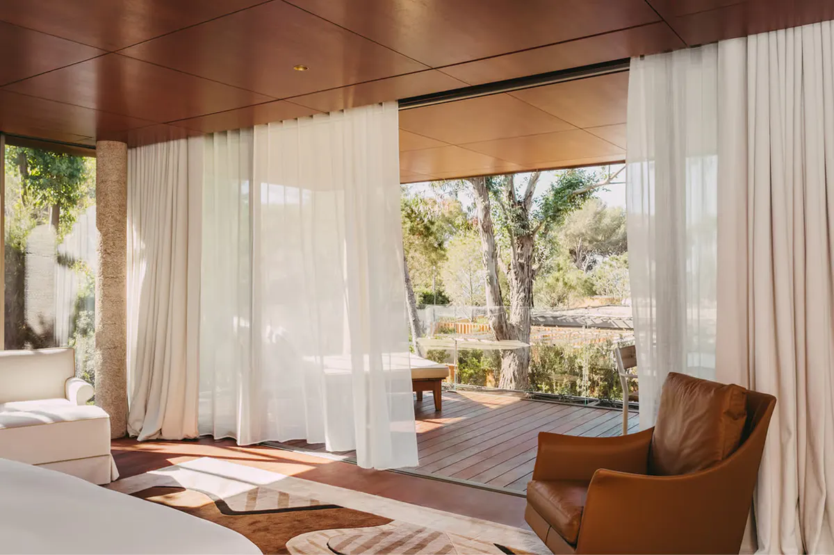 Spa lounge with sheer curtains and chairs facing Mediterranean scenery
