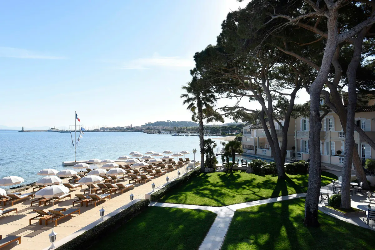 Beachfront lawn with pines and Mediterranean vista from the property
