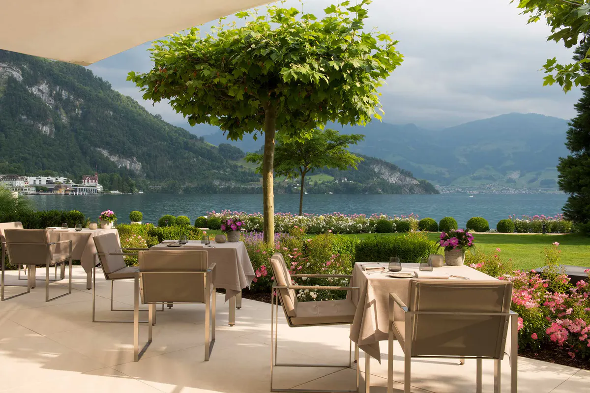Landscaped terrace with valley views and dining chairs under an umbrella
