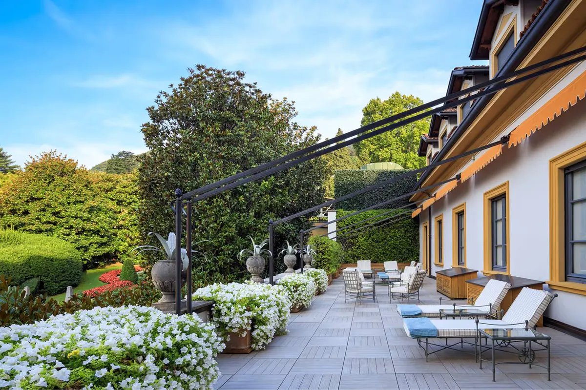 Terraced garden area with lounging space among manicured green lawns and plants