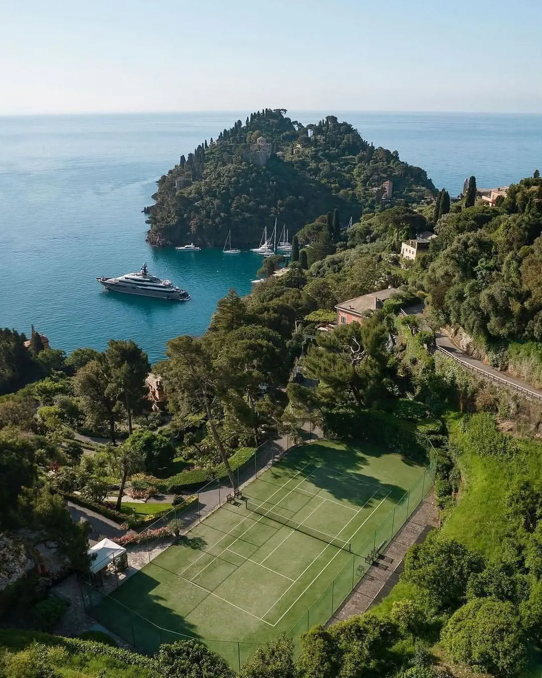 A yacht at anchor off the pine-clad Portofino headland