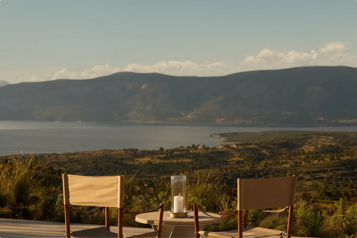 Alfresco dining at dusk with fire bowl and distant sea horizon
