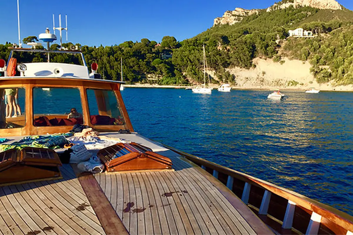 Sunny terrace with cushioned sun loungers overlooking Mediterranean Sea and pine trees