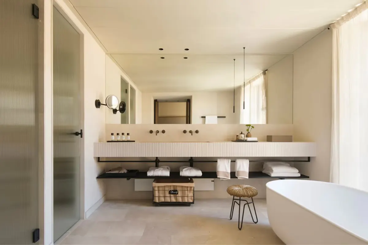 Spa bathroom with double vanity and soaking tub beside window