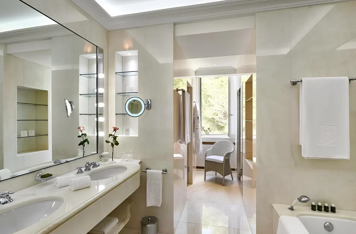 An open-plan residence with cream sofa, glass railings, natural wood accents, and views to green grounds