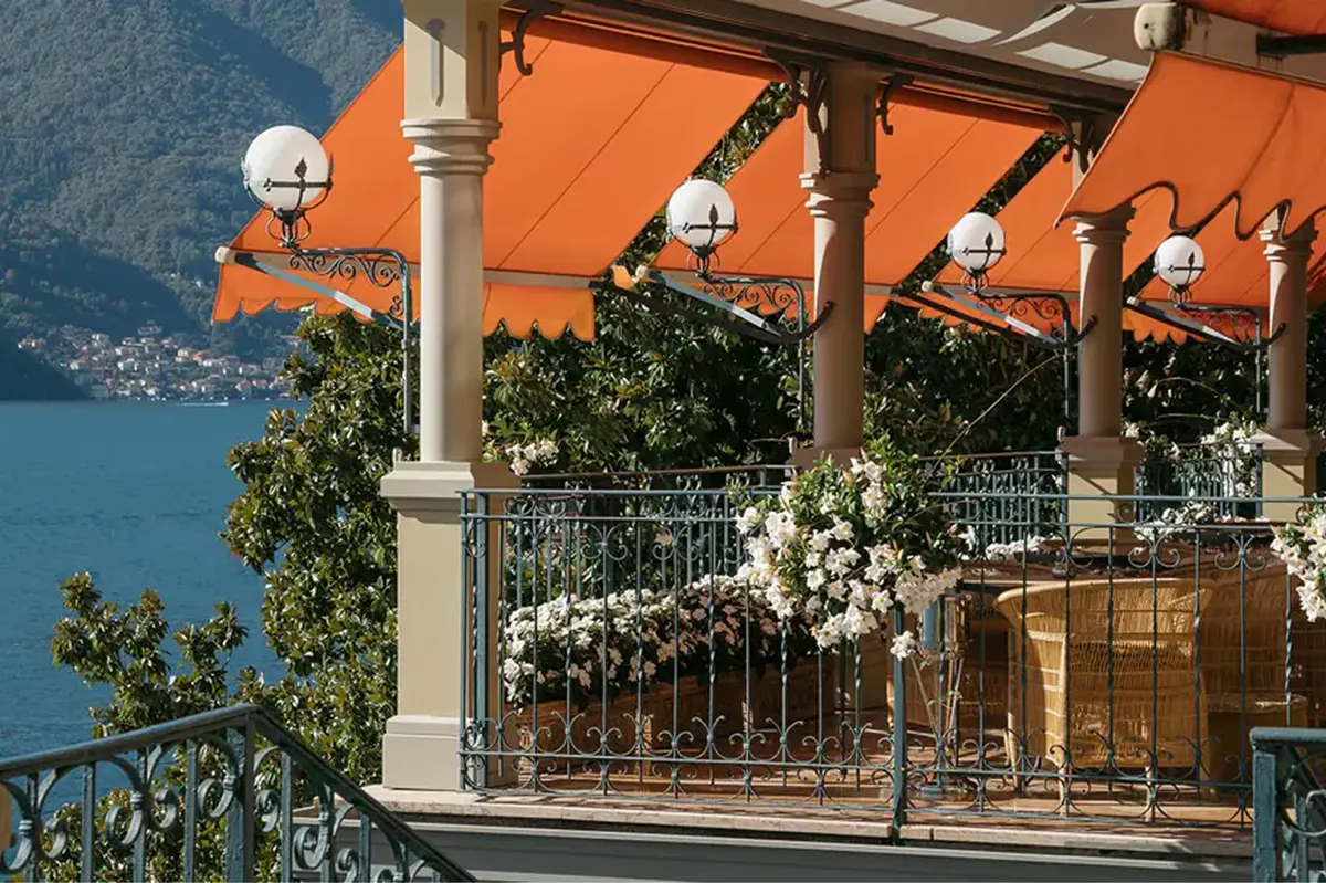 Lakeside terrace with orange umbrellas and railing overlooking water
