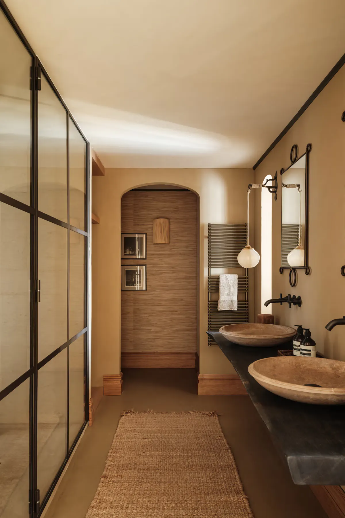 Dressing alcove with floor-length curtains, tall framed mirror, patterned woven stool, crisp white shelving