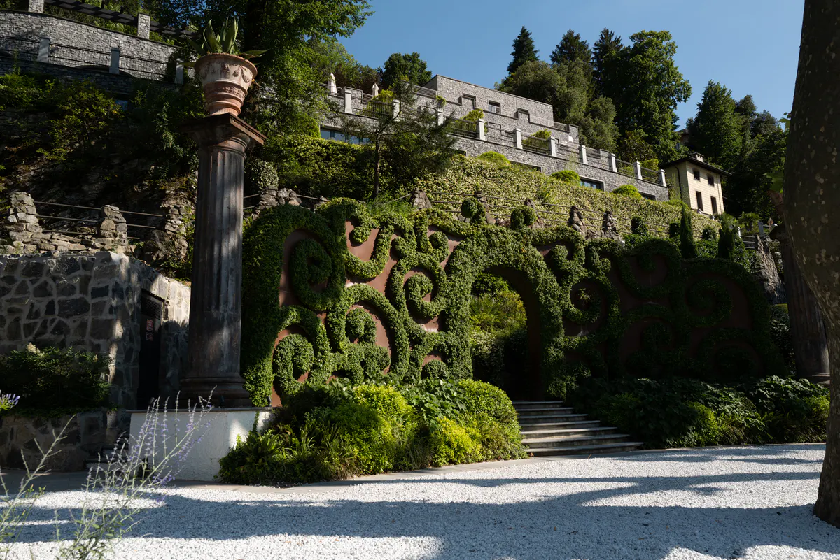 Stacked villas on a green hillside with stone architecture and manicured landscaping