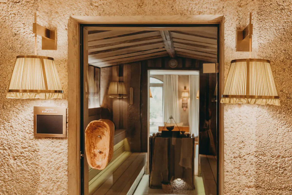 Entry to spa treatment room with natural stone archway and warm lighting
