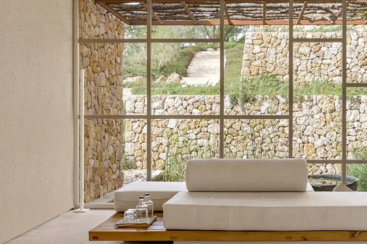 Wellness room with window seating alcove, layered stone wall, and minimalist furnishings