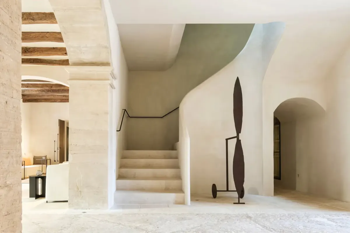 Minimalist hallway with stone archway and modern sculptural black decor