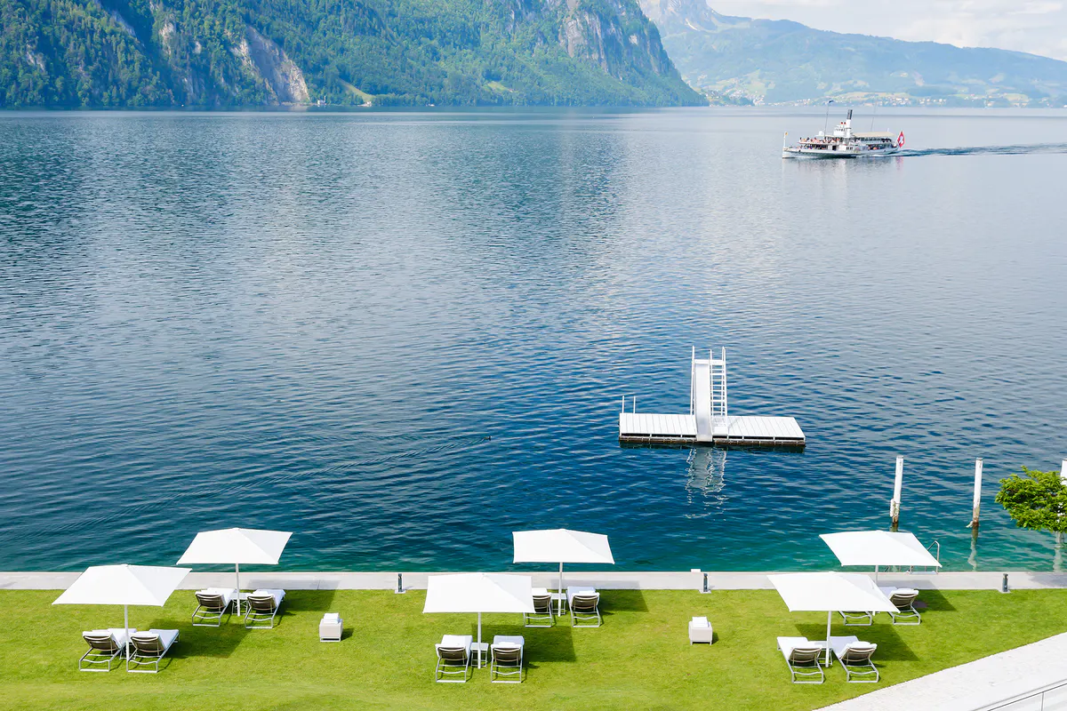 Waterfront promenade with floating dock and lawn seating overlooking the lake