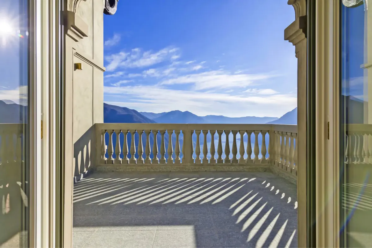 Large terrace doors framing sweeping lake and mountain views across Lake Como