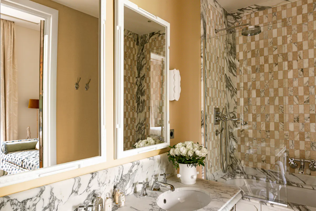 Bathroom with marble sink, patterned tile detail, and wood cabinetry