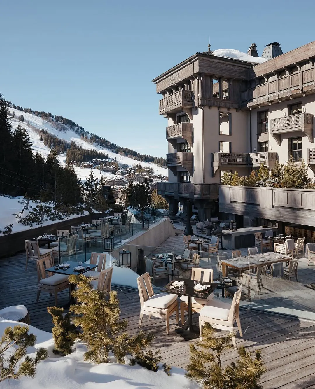 Chalet exterior and terrace dining deck overlooking the village, ski slopes, and mountains