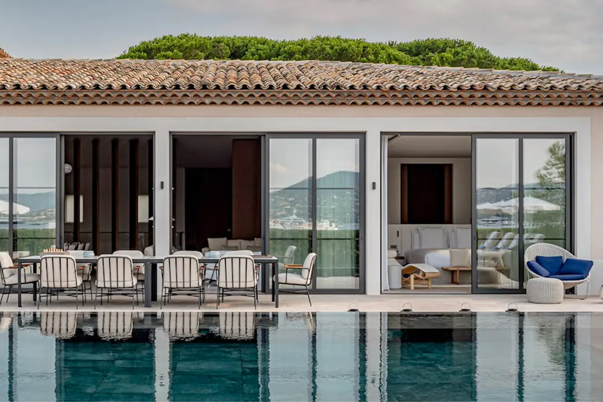 Villa exterior with green roof, infinity pool, and open terraces