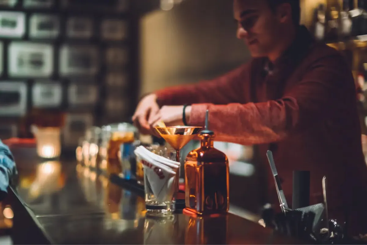 The bar area with warm wood tones and glasses displayed for cocktail service