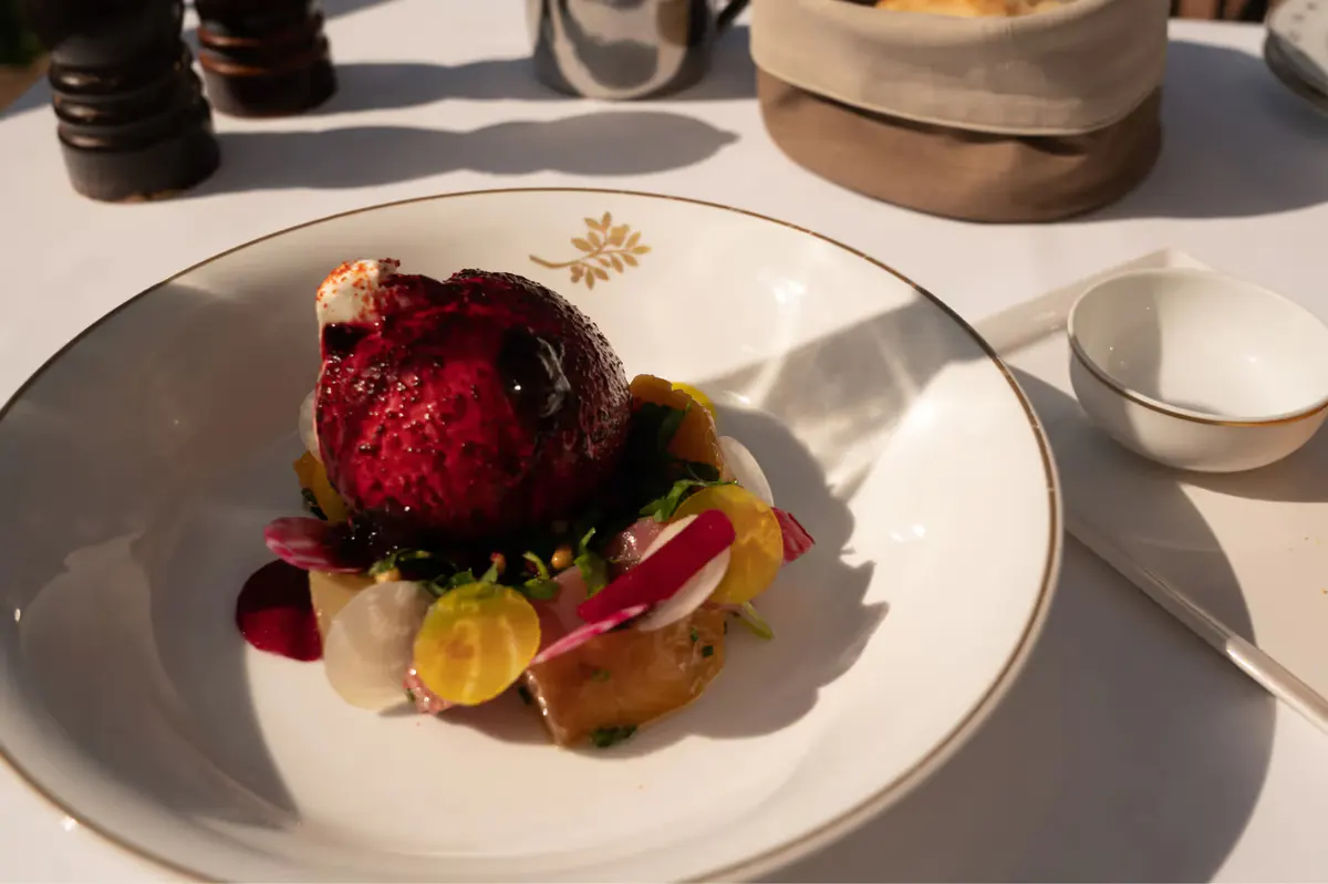 Plated dessert with red berry coulis and gold leaf accent
