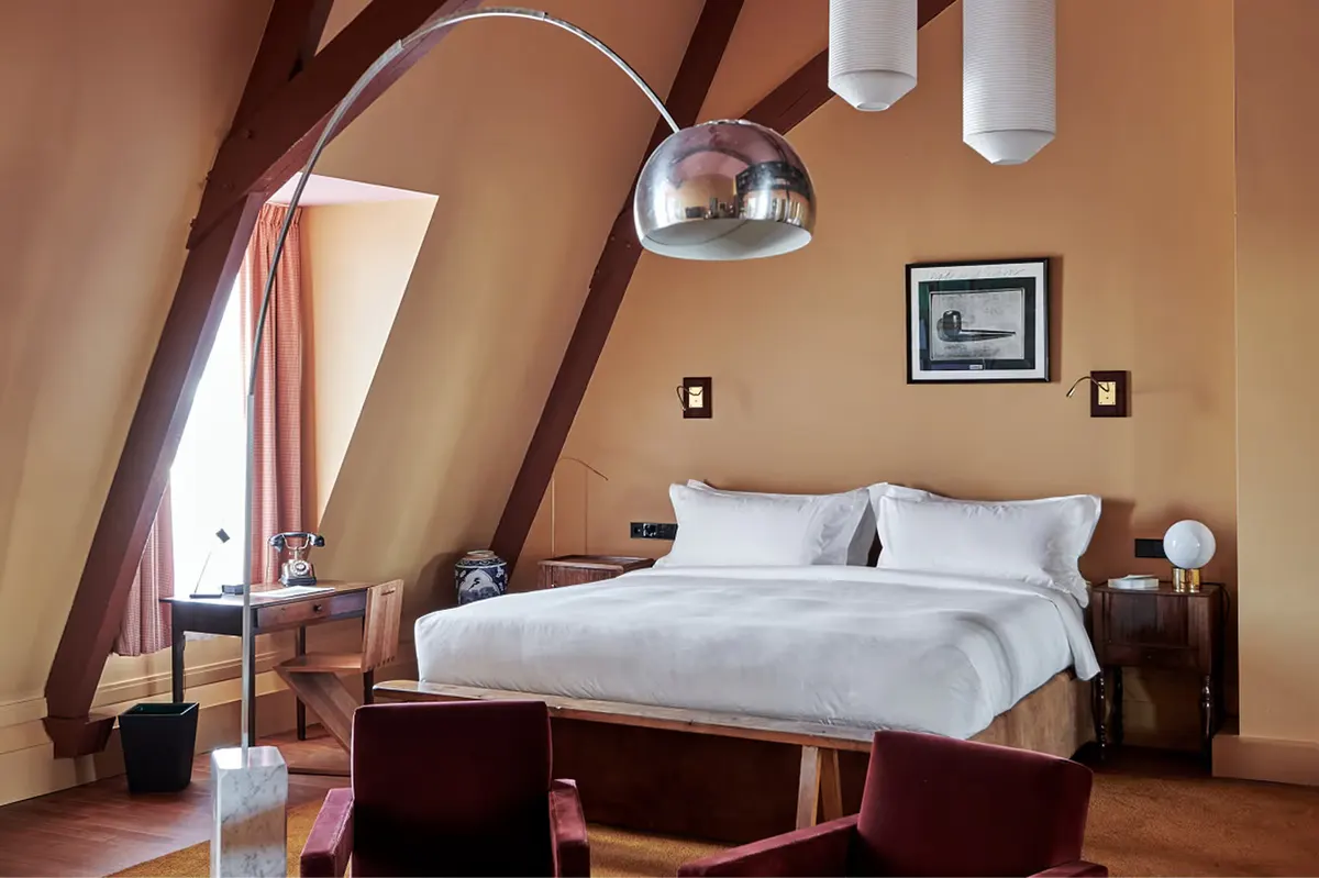 Attic bedroom with sloped ceiling, arched window detail, and compact layout