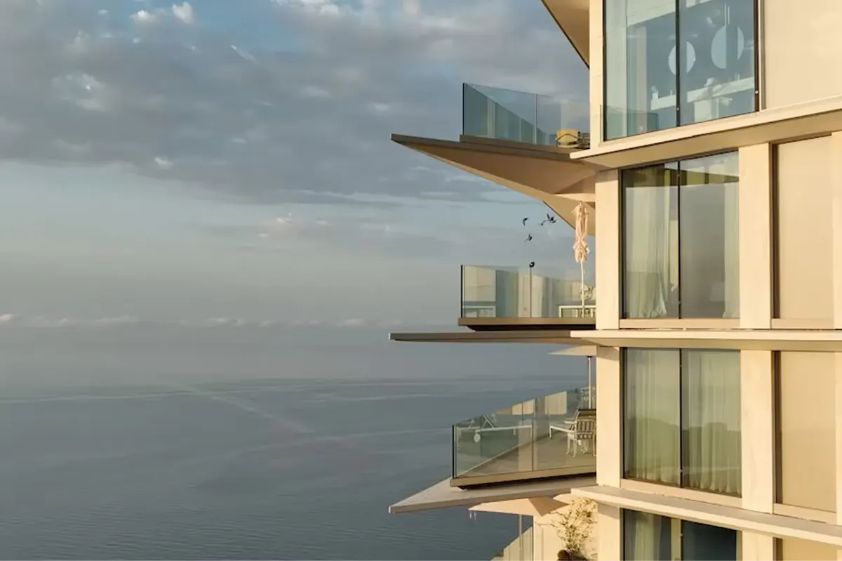 Stacked terraces and glass balconies above sea