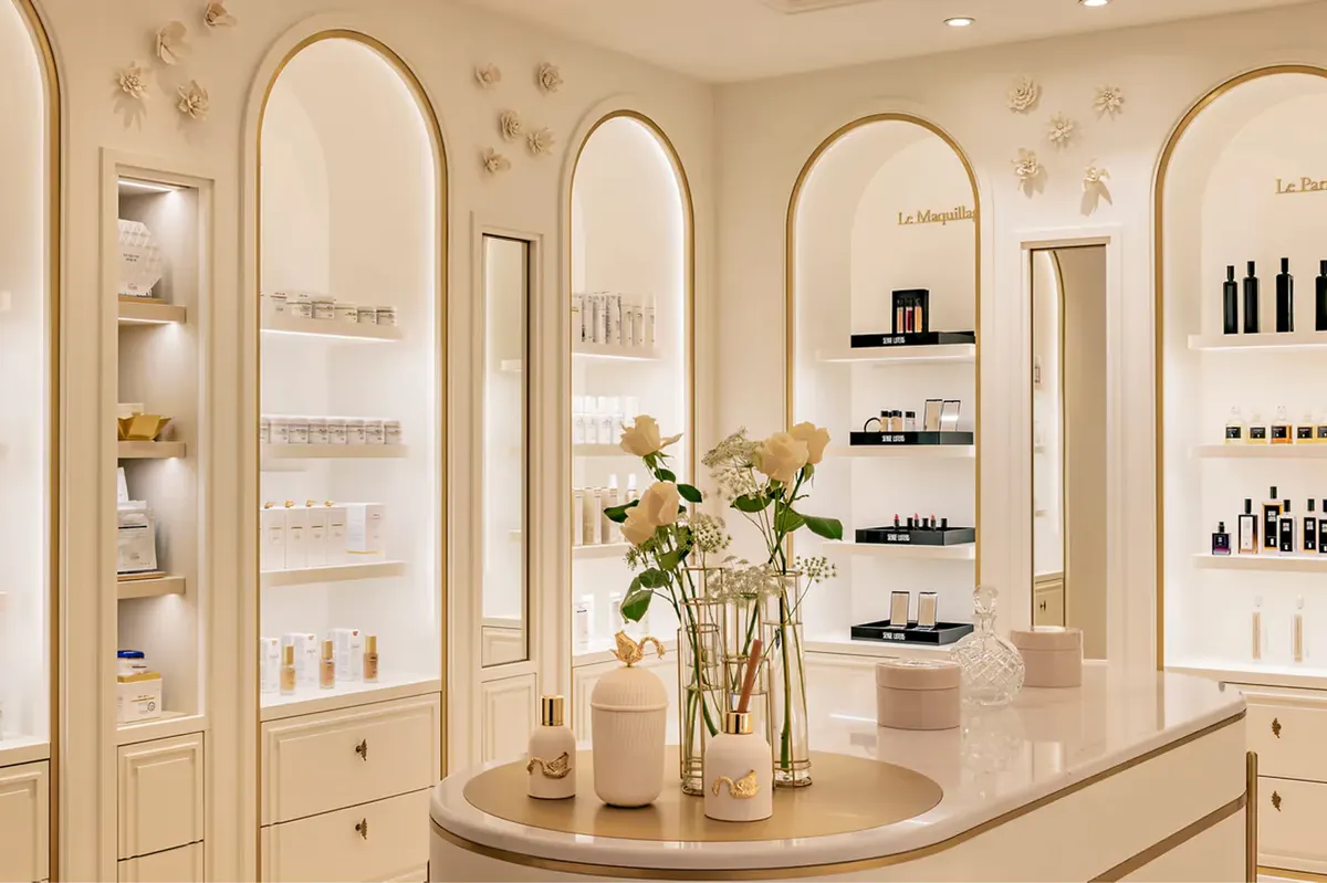 A beauty salon interior with illuminated arched mirrors and product display shelving