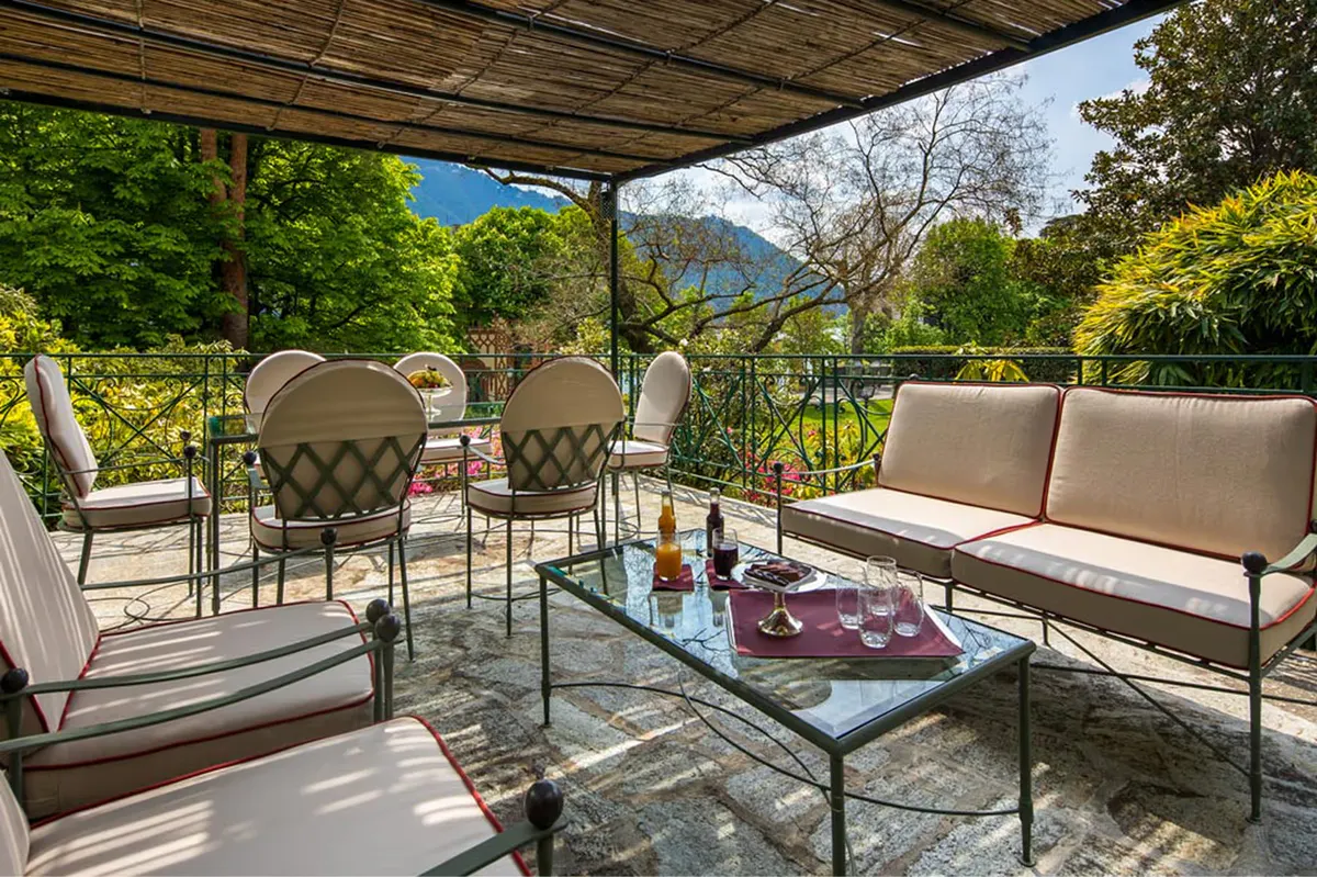 Shaded terrace with stone dining table and mountain and water views