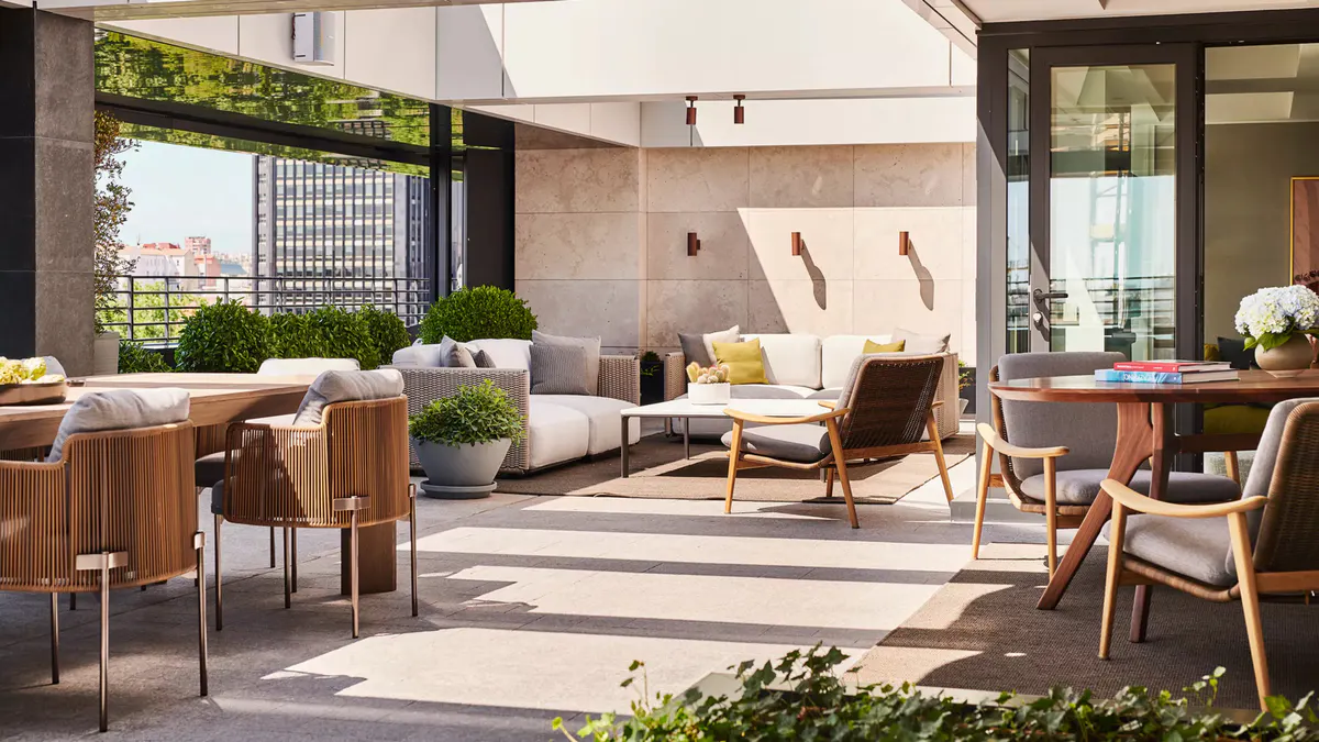 A covered courtyard with lounge seating, neutral upholstery, and skylight above
